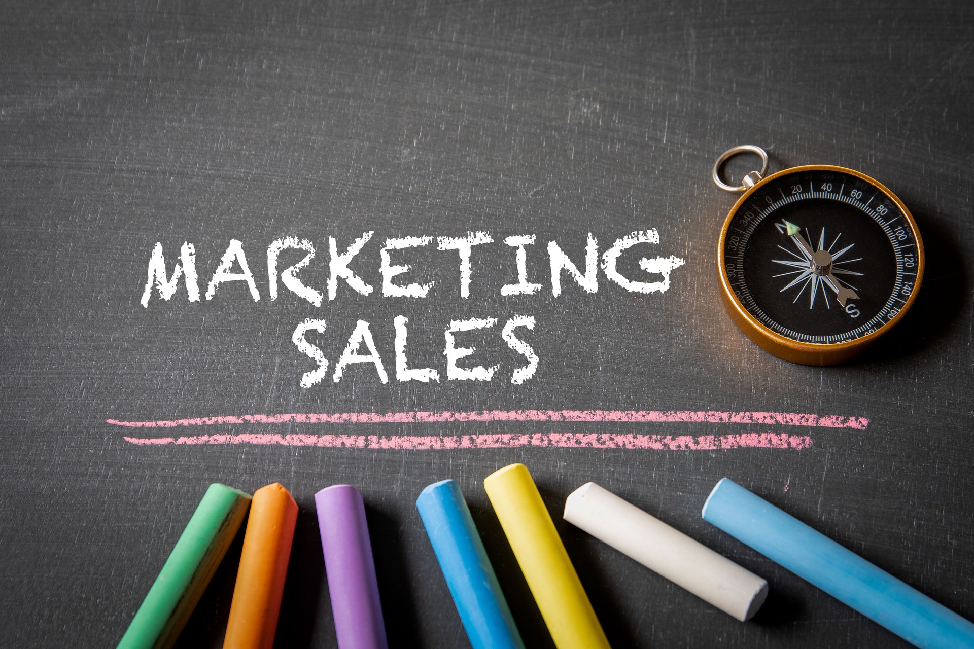 Marketing Sales. Compass and colored pieces of chalk on a blackboard